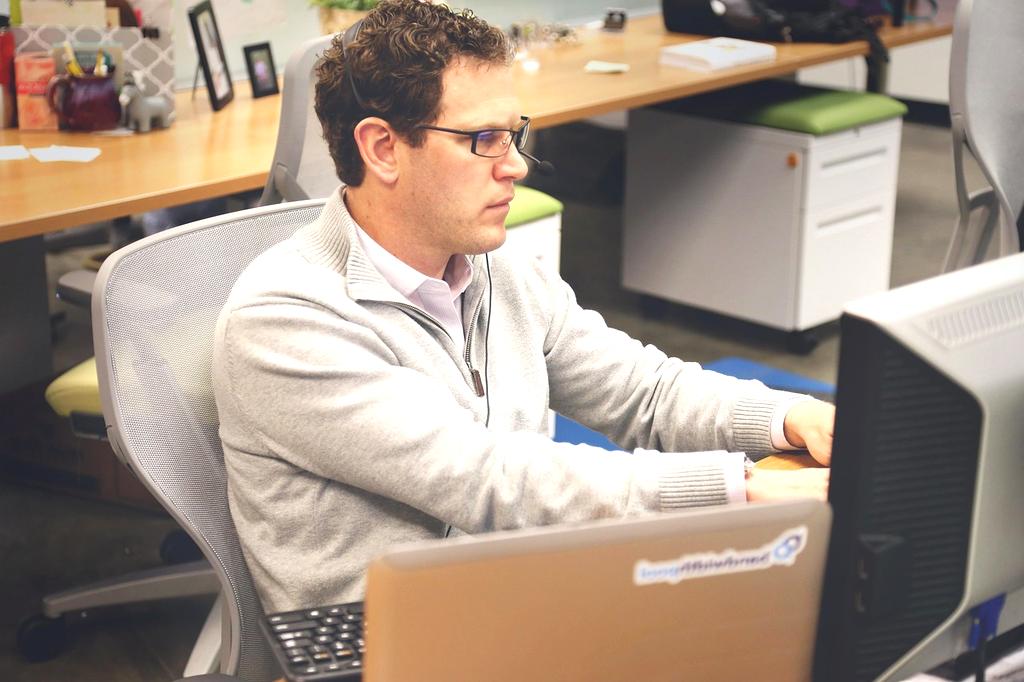 Person writing blog on laptop in a modern tech workspace